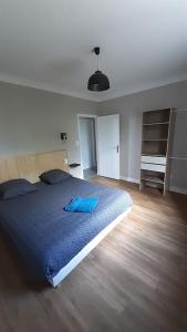 une chambre avec un grand lit avec une couverture bleue dans l'établissement LA Maison D'AGEN, à Boé