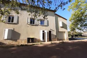 une grande maison blanche avec des fenêtres blanches à volets dans l'établissement LA Maison D'AGEN, à Boé