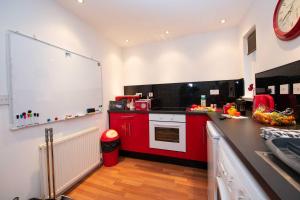 una cucina con armadi rossi e stufa bianca di PREMIER - Chapel Street Apartment a Cleland