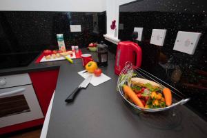 a kitchen counter with a bowl of vegetables on it at PREMIER - Chapel House with Driveway! in Cleland +13 photos