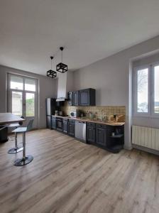 uma grande cozinha com pisos de madeira e uma mesa em La Maison des Martinettes em Étauliers