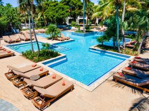 威廉斯塔德的住宿－Zoetry Curacao，享有带躺椅和棕榈树的游泳池的顶部景致