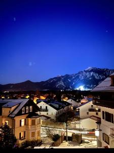 uitzicht op een stad in de nacht met besneeuwde bergen bij Ferienwohnung Oya in Füssen