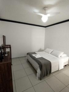 a bedroom with a white bed and a ceiling at Flat Schnneider, Hospedagem econômica, empresas, diárias in Taubaté