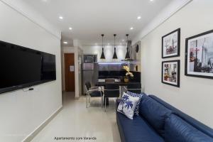 a living room with a blue couch and a dining room at Apto 2Q com varanda no Ed Maximum Home in Natal +14 photos