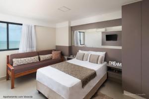 a bedroom with a bed and a couch at Apto 2Q com varanda no Ed Maximum Home in Natal