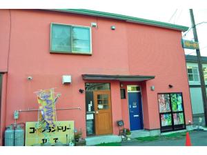 un edificio rojo con un cartel delante en Guest House HiDE - Vacation STAY 64843v, en Lago Toya