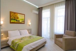 a bedroom with a bed and a chair and a window at Summit Apartments in Kyiv