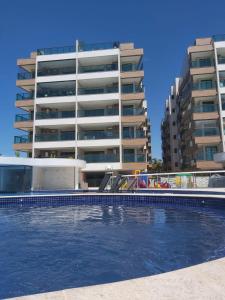a large swimming pool in front of a building at Anjos Beach in Arraial do Cabo
