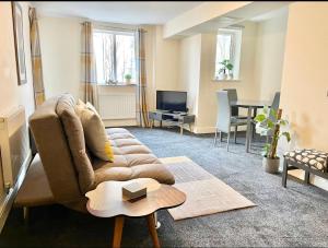 a living room with a couch and a table at Ashford Modern Apartments, central location wt parking great location for holidays! in Ashford