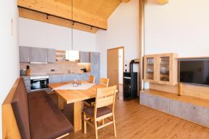 a kitchen and dining room with a wooden table at Alpenpanorama Konzett in Faschina