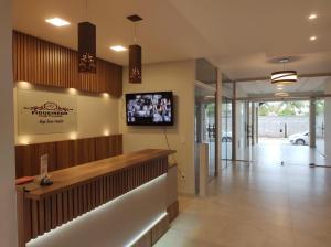 a lobby of a restaurant with a tv on the wall at Hotel Pousada Figueiredo in Araruama