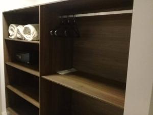 a cupboard with wooden shelves in a room at Hotel Vilhar in Ivaiporã