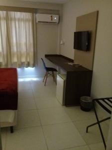 a kitchen with a desk and a chair in a room at Hotel Vilhar in Ivaiporã