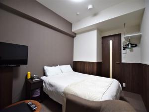een hotelkamer met een bed en een flatscreen-tv bij Land-Residential Hotel Fukuoka - Vacation STAY 81812v in Fukuoka