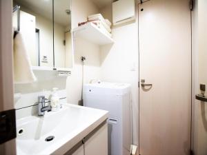 een badkamer met een wastafel, een toilet en een spiegel bij Land-Residential Hotel Fukuoka - Vacation STAY 81812v in Fukuoka