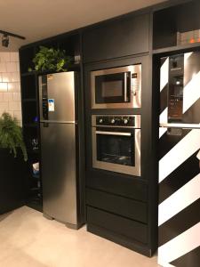 uma cozinha com um frigorífico e um micro-ondas em Artsy Vitoria Hostel em Vitória