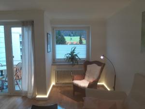 Una sala de estar con una silla y una ventana. en Weitblick, en Bad Harzburg 8 fotos más