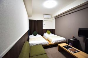 Cette chambre comprend deux lits, un canapé et une télévision. dans l'établissement Land-Residential Hotel Fukuoka - Vacation STAY 81843v, à Fukuoka