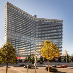 un grande edificio con auto parcheggiate in un parcheggio di Pentahotel Moscow, Arbat a Mosca