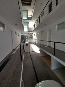 um corredor de um edifício vazio com bancos e clarabóias em Flat Schnneider, Hospedagem econômica, empresas, diárias em Taubaté