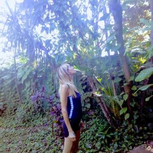 a woman standing in front of a garden at Posada María Iguazú in Puerto Iguazú