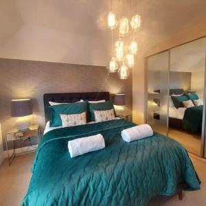 een slaapkamer met een groot groen bed met 2 kussens bij NewForest-Spacious-4BDHolidayHome-Garden-Parking in Ringwood