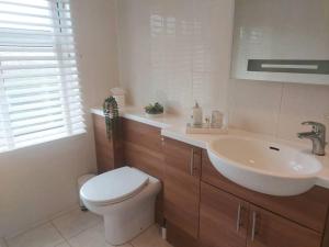 ein Badezimmer mit einem weißen WC und einem Waschbecken in der Unterkunft NewForest-Spacious-4BDHolidayHome-Garden-Parking in Ringwood