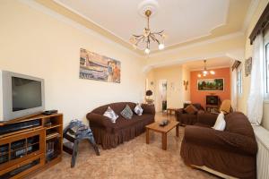 sala de estar con sofás y TV de pantalla plana. en Dimitris Luxury Apartment, en Kaligata