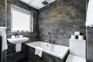a bathroom with a tub and a sink at Lovely 2 Bedroom Apartment Near South Bank in London