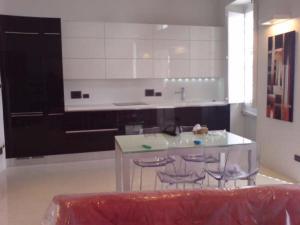 a kitchen with a table and three stools in it at Nr65 Valletta Portview Apartment in Valletta