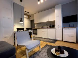 a kitchen and a living room with a table at URABN APARTMENTS Studio with garden No 2A Chorzów Katowice FREE PRIVATE PARKING in Chorzów