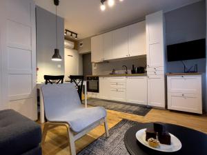 a kitchen and a living room with a table at URABN APARTMENTS Studio with garden No 2A Chorzów Katowice FREE PRIVATE PARKING, Self CHECK-IN in Chorzów