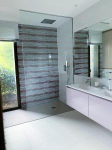 a bathroom with a tub and a sink and a mirror at Appartement Regard-sur-mer 165m2 4ch vue mer piscine in Carqueiranne