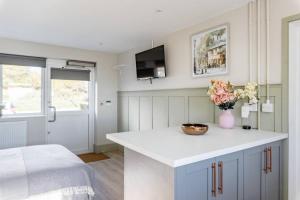 uma cozinha com um balcão com um vaso de flores em Seaview 1 bed open condo - free parking em Brighton & Hove