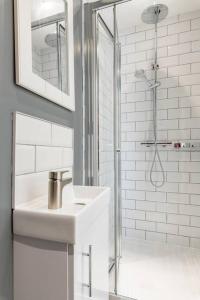 a white bathroom with a sink and a shower at Seaview 1 bed open condo - free parking in Brighton & Hove