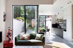 a living room with a green couch and glass doors at Suite lumineuse à Saint-Gilles in Brussels