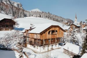 un lodge en la nieve con árboles nevados en Apartment Sotmarin, en La Villa