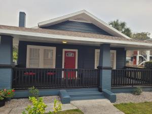 a blue house with a red door and a porch at Modern Two Bedroom Home in Lakeland