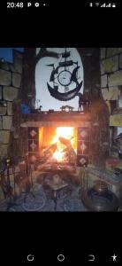 a fireplace with a clock and a ship in it at Maison de rêve in Tabarka