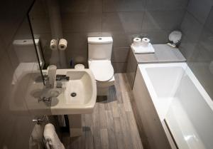 a bathroom with a white sink and a toilet at Cornerhouse Apartments Llandudno in Llandudno +26 photos