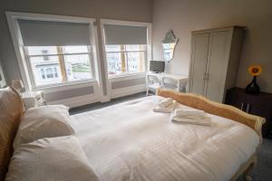 a bedroom with a large bed with two towels on it at Cornerhouse Apartments Llandudno in Llandudno