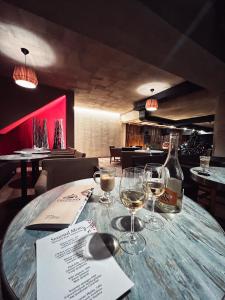 a table with wine glasses and a bottle of wine at Teghenis Resort in Tsaghkadzor