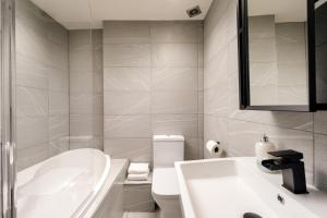 La salle de bains est pourvue d'une baignoire, de toilettes et d'un lavabo. dans l'établissement Spacious 2BR Leith Apartment, à Édimbourg