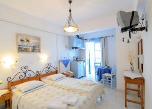 a bedroom with a bed, a desk and a lamp at Pension Ilias in Amorgos