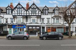 two cars parked in front of a building at The North Shore in Llandudno