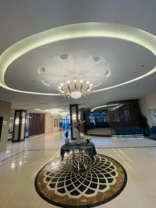 a lobby with a chandelier and a table on a rug at فندق وريف الشرق in Sarat Abidah