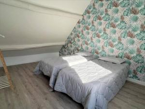 uma pequena cama num quarto com uma parede em Maison à 6min du Parc Disneyland Paris em Magny-le-Hongre