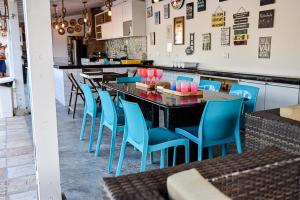 um restaurante com cadeiras azuis e uma mesa preta em CASA SERRAMBI - 7QTS + PISCINA PRIVATIVA BY SEU FLAT em Porto de Galinhas
