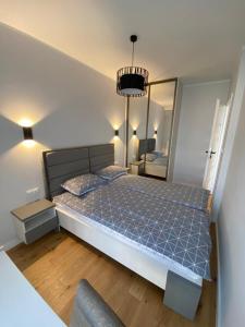 a bedroom with a bed and a large mirror at APARTAMENT AURA RYBAKI in Gdańsk